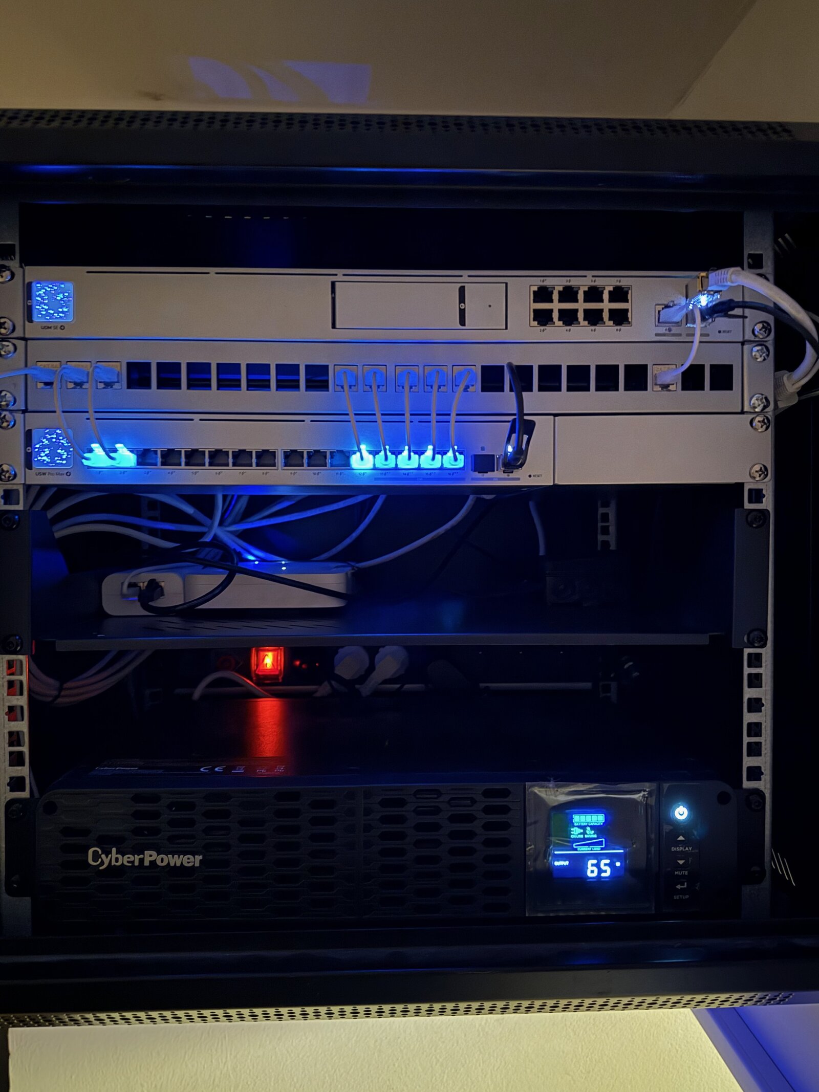 Datový rozvaděč s UniFi switchi, patch panelem a UPS — strukturovaná kabeláž kanceláří MECH.cz